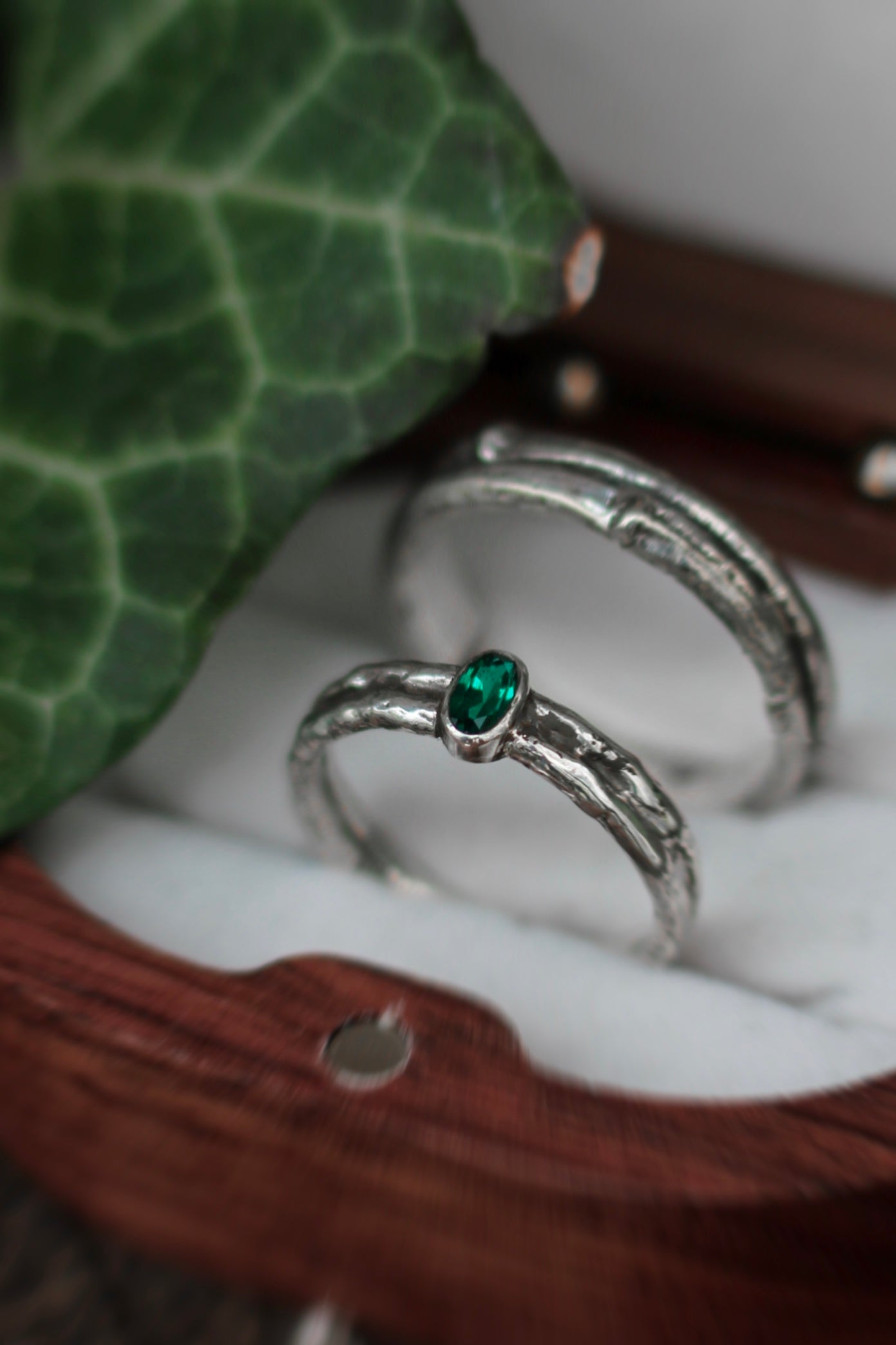 silver wedding ring with emerald stone and treebank texture