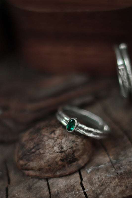 silver wedding ring with emerald stone and treebank texture