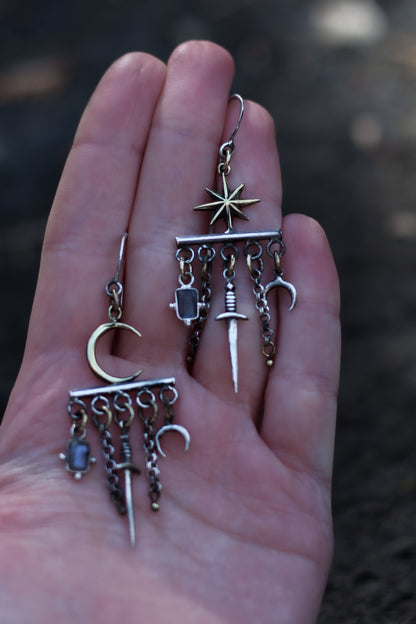 velar celestial moon and star swords earrings held in the hand