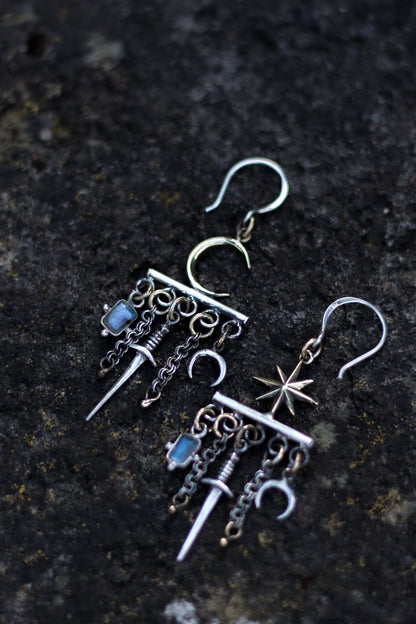 velar celestial moon and star swords earrings flat lay picture